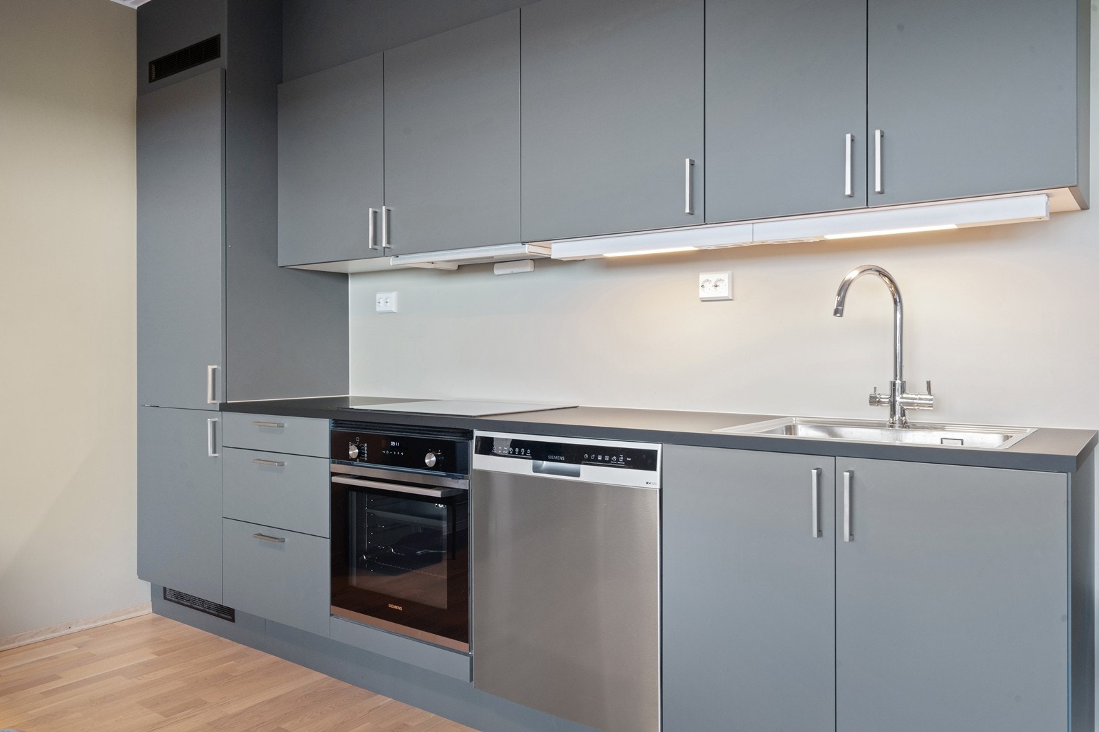 Delikat og stilig kjøkkeninnredning med integrert kjøleskap med fryser, stekeovn samt plass til oppvaskmaskin og platetopp Galleribilde