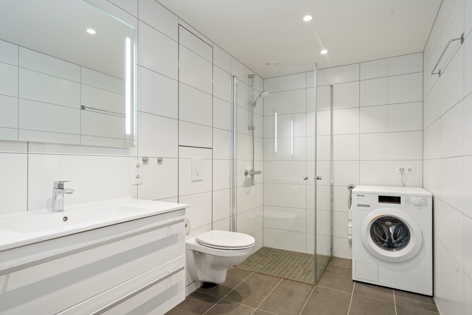 Pent flislagt bad med bl.a opplegg for vaskemaskin Galleribilde