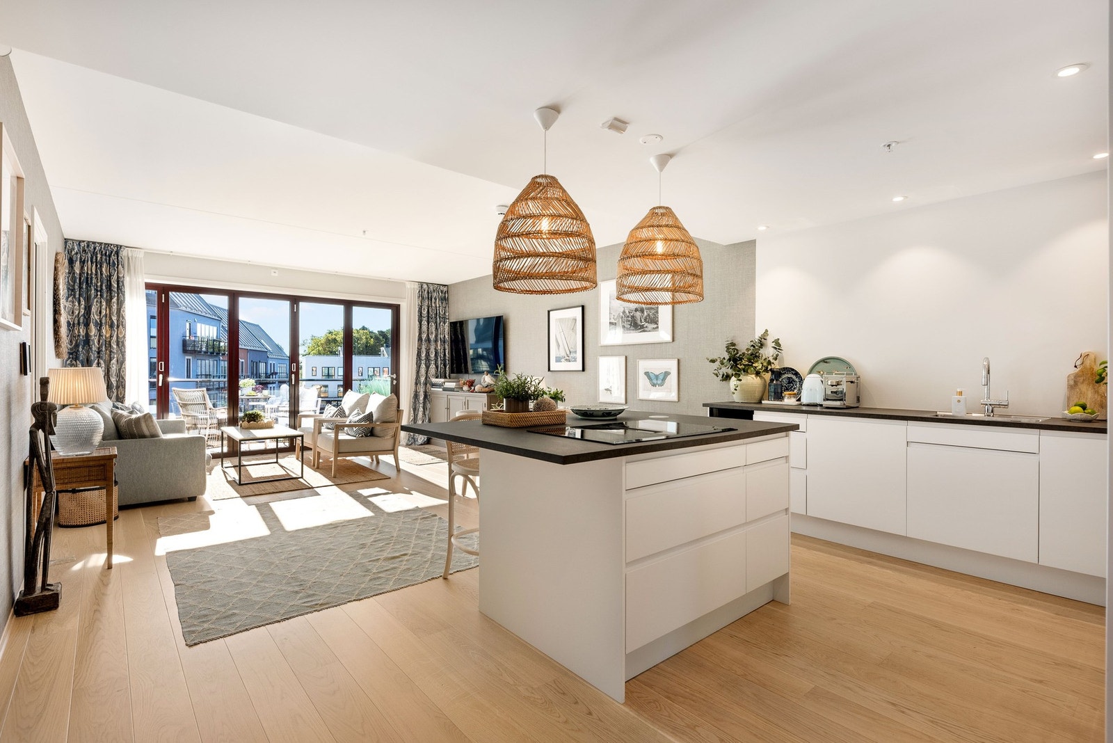 Lys og moderne åpen stue- og kjøkkenløsning med store vindusflater. Galleribilde