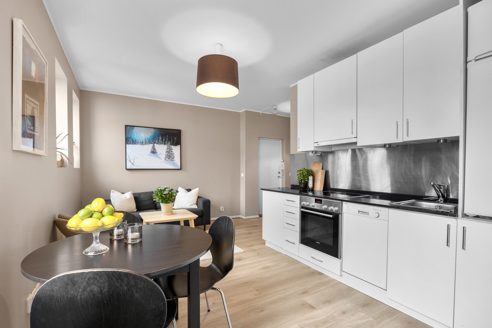 Kjøkkenet har et lyst og tidløst design med benkeplate i stein. Galleribilde