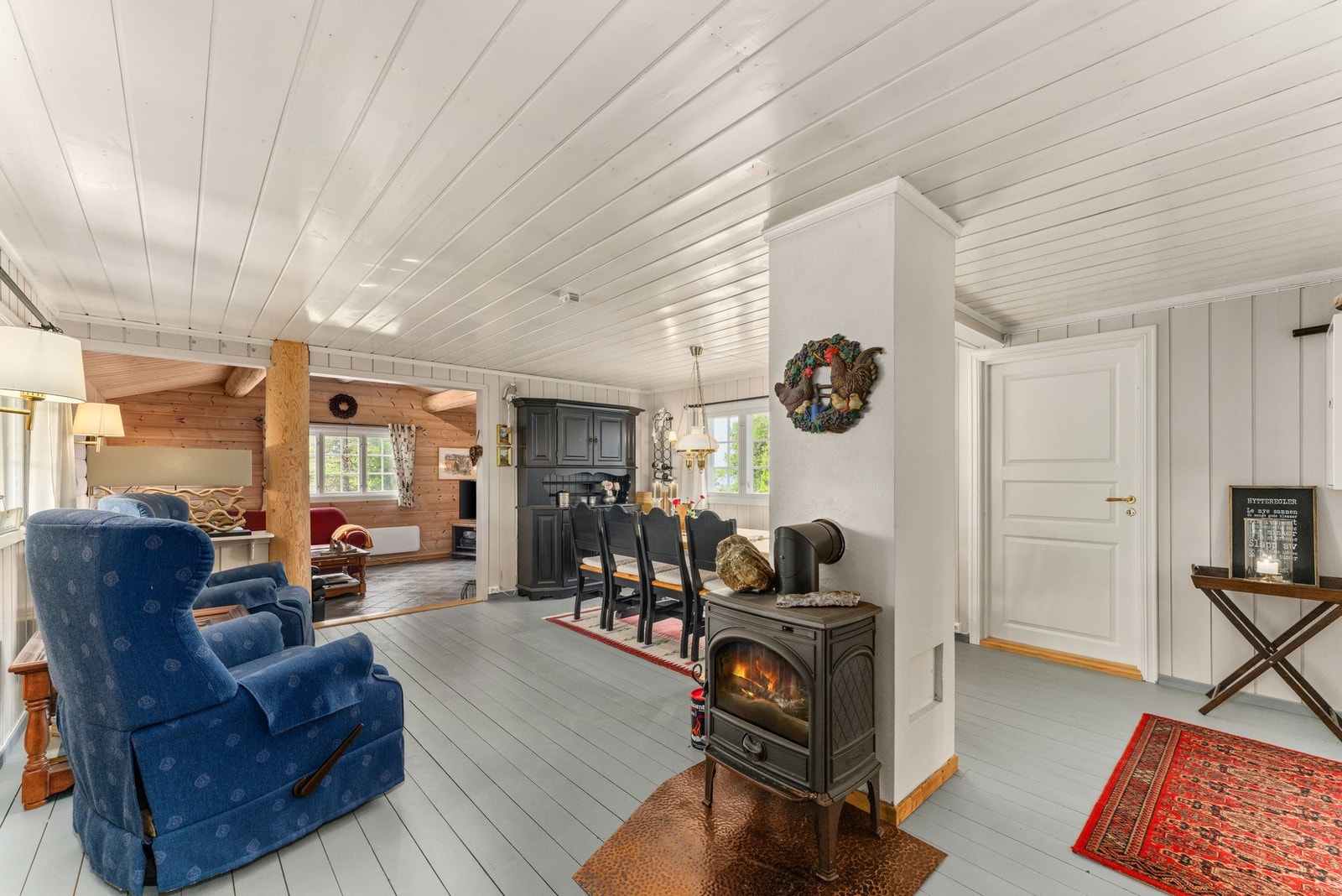 Videre inn kommer du til en romslig spisestue med tregulv og panelerte vegger og tak, som gir rommet en varm og autentisk hyttefølelse. Galleribilde