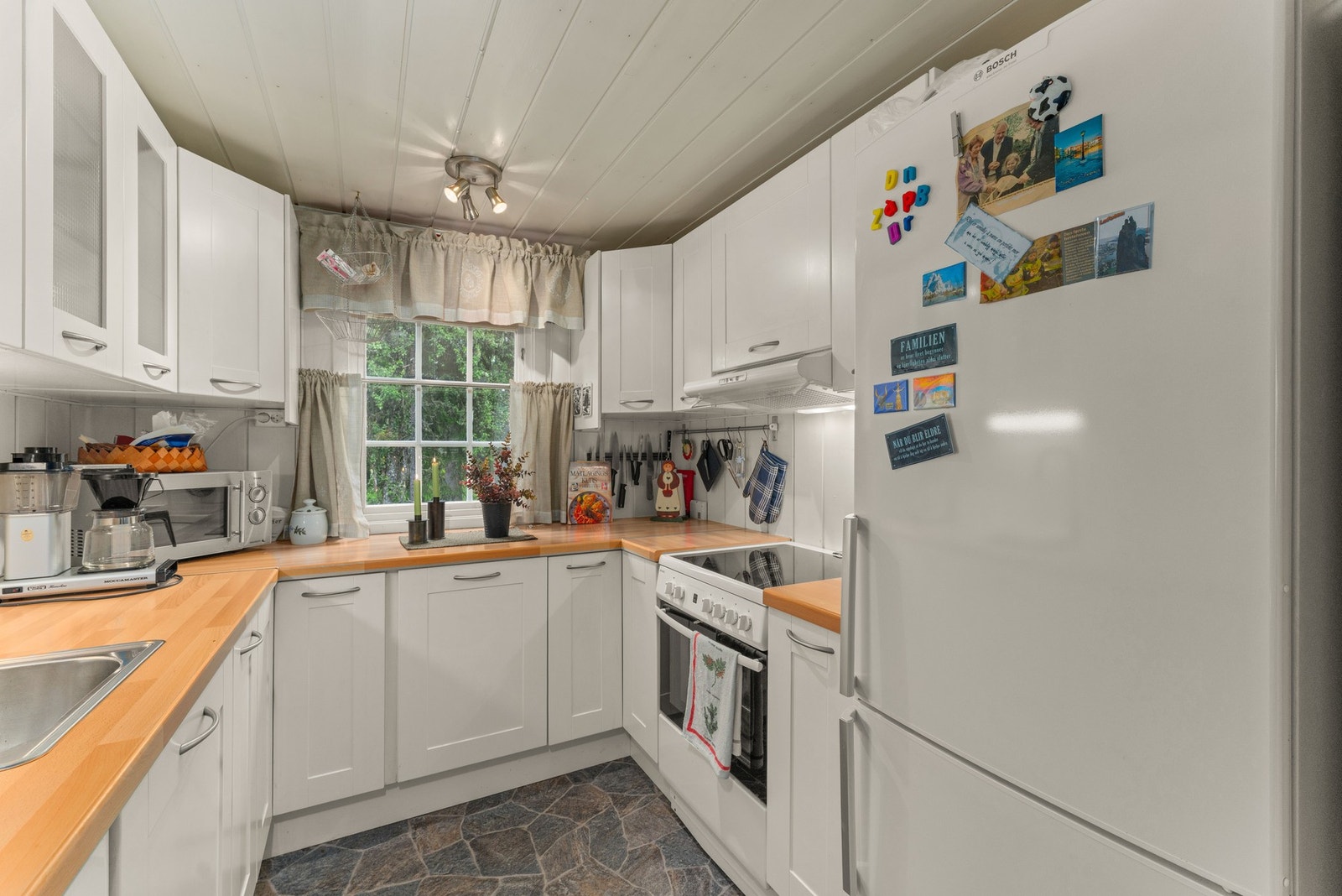 Innredningen består av laminerte skrog med profilerte fronter, og en laminert benkeplate med belysning over. Her finner du kjøkkenkum og komfyrvakt, plass til integrert oppvaskmaskin og plass til frittstående komfyr og kjøleskap. Galleribilde