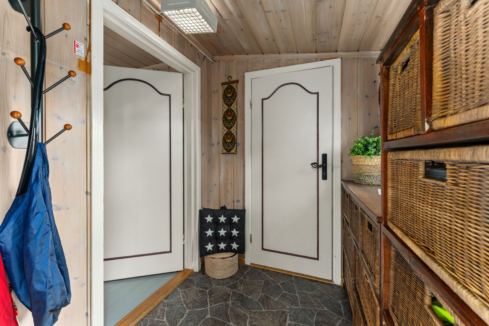 Hytta ønsker deg velkommen med en praktisk entré med fliser på gulvet. Praktisk kommode- og skuffeløsning gir rikelig med oppbevaringsplass til yttertøy og utstyr. Galleribilde