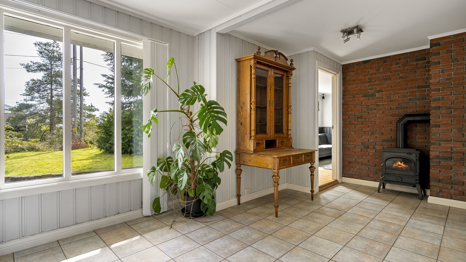 Lys gang med store vinduer og vedovn. Galleribilde