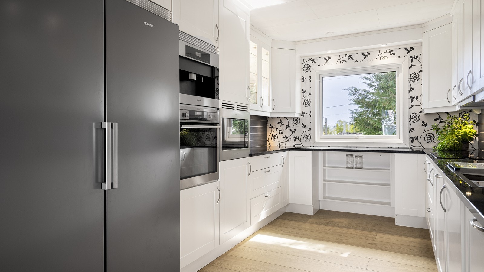 Moderne kjøkken med god skapplass og integrerte hvitevarer Galleribilde