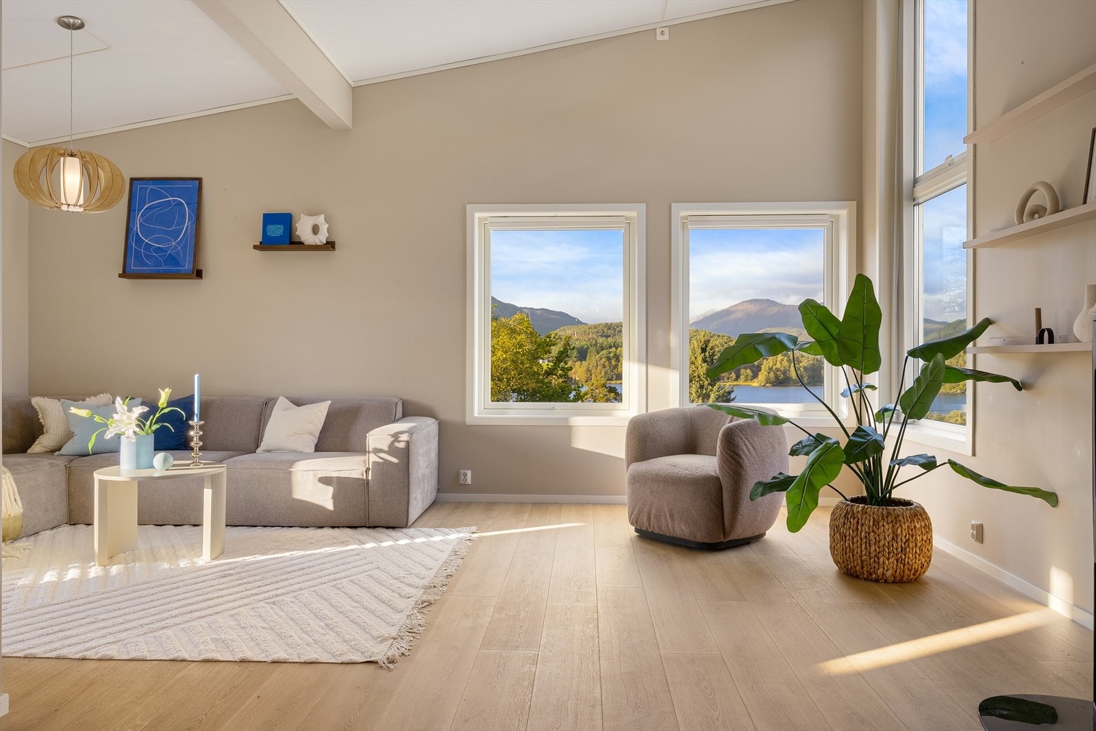 Et luftig oppholdsrom der utsikten og takhøyden setter preg på atmosfæren Galleribilde