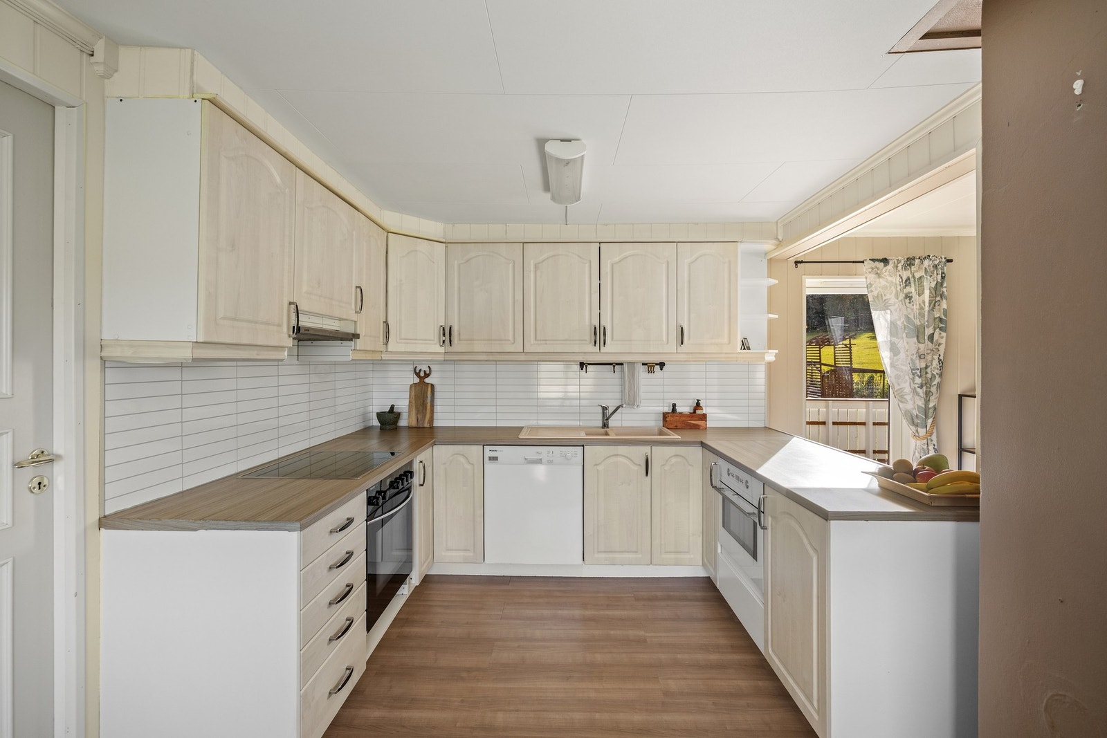 Kjøkken - 14 kvm. Pen innredning med integrert stekeovn, platetopp og oppvaskmaskin Galleribilde