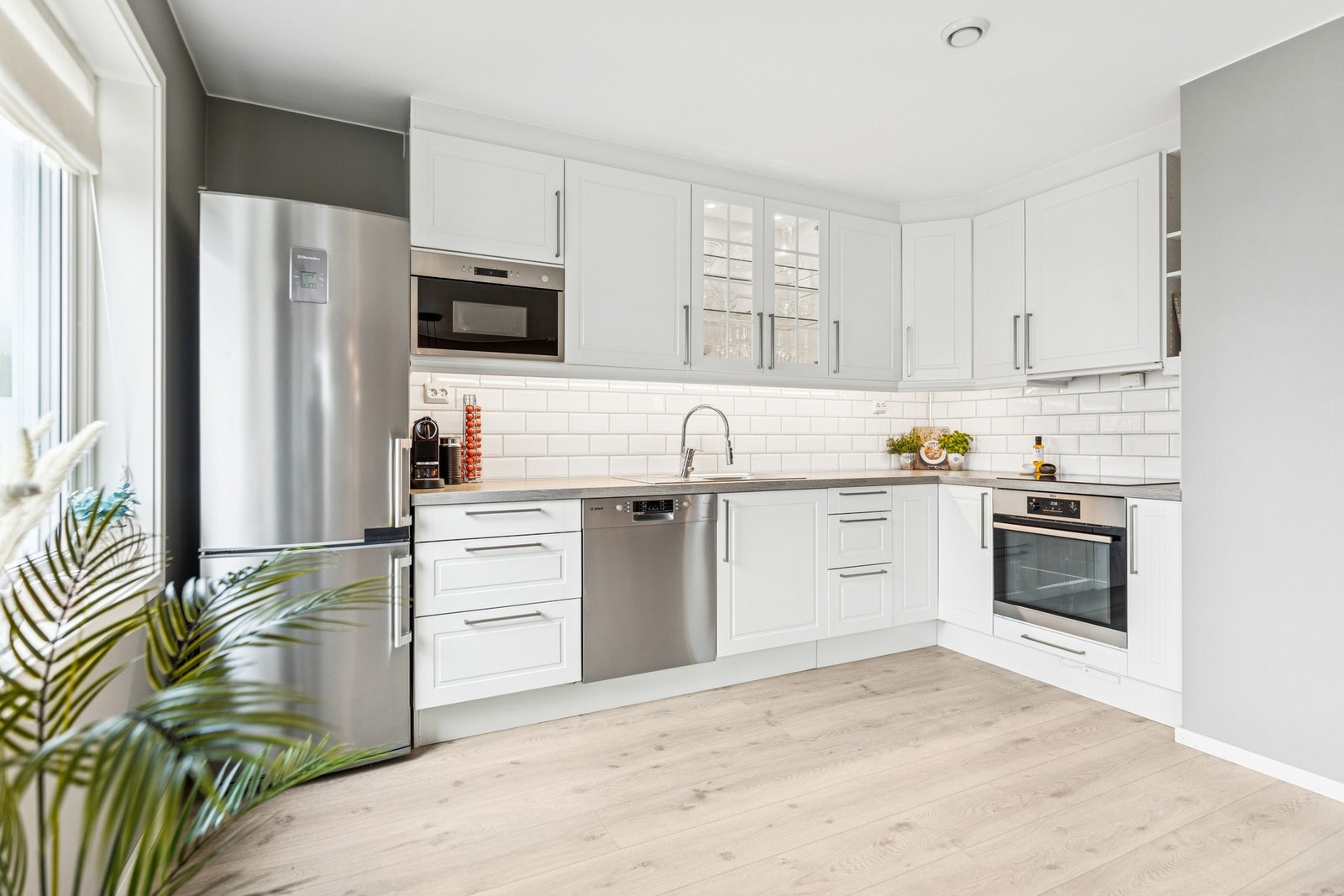 Kjøkkeninnredningen er tidløs og moderne med lyse profilerte fronter og laminat benkeplate. Galleribilde