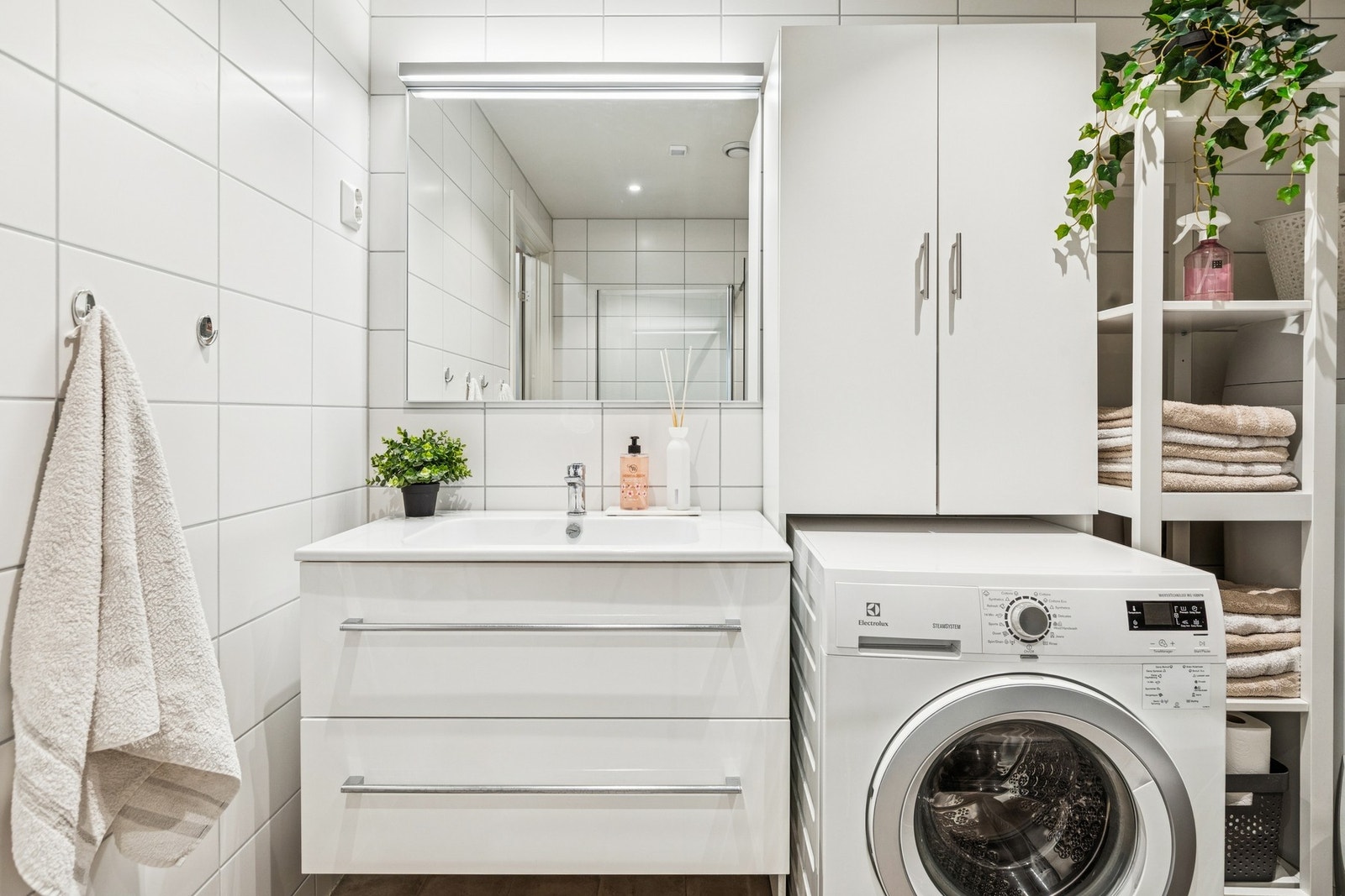 Fullt flislagt baderom i pent moderne design med gulvvarme, vegghengt servantinnredning med heldekkende servant. Galleribilde