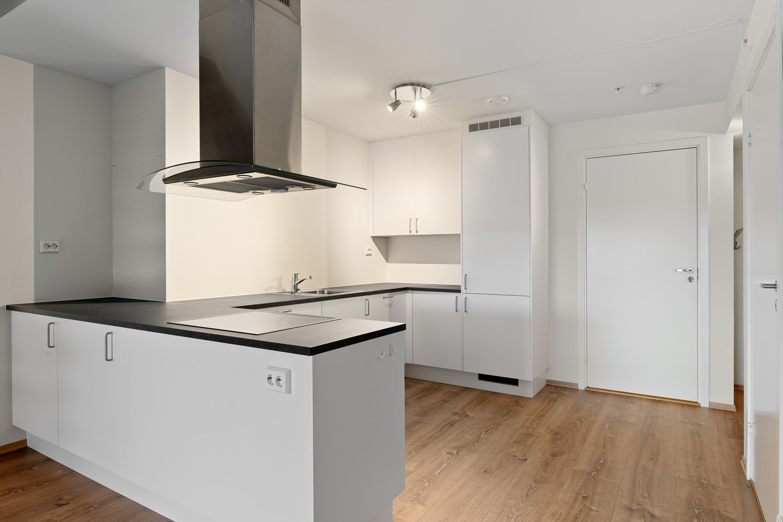 Pent kjøkken i hvit utførelse. Integrerte hvitevarer medfølger. Galleribilde