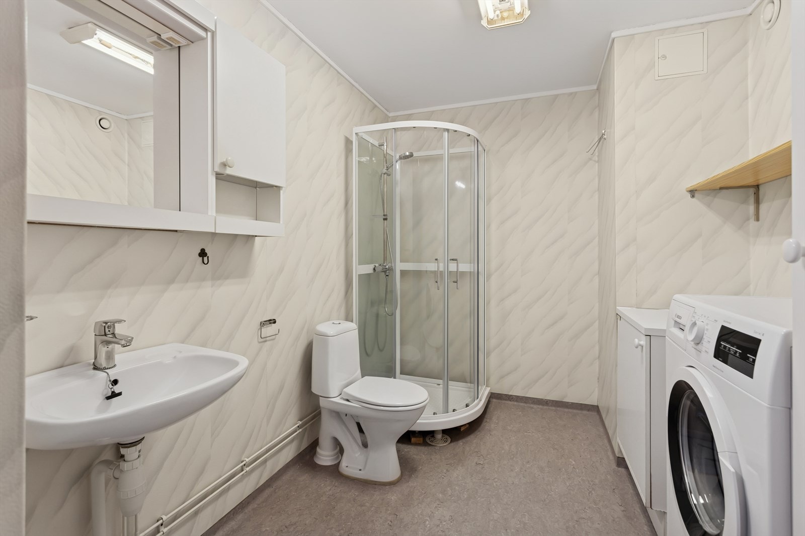 Leiligheten har et eldre baderom med gulvbelegg og varme i gulv. Galleribilde