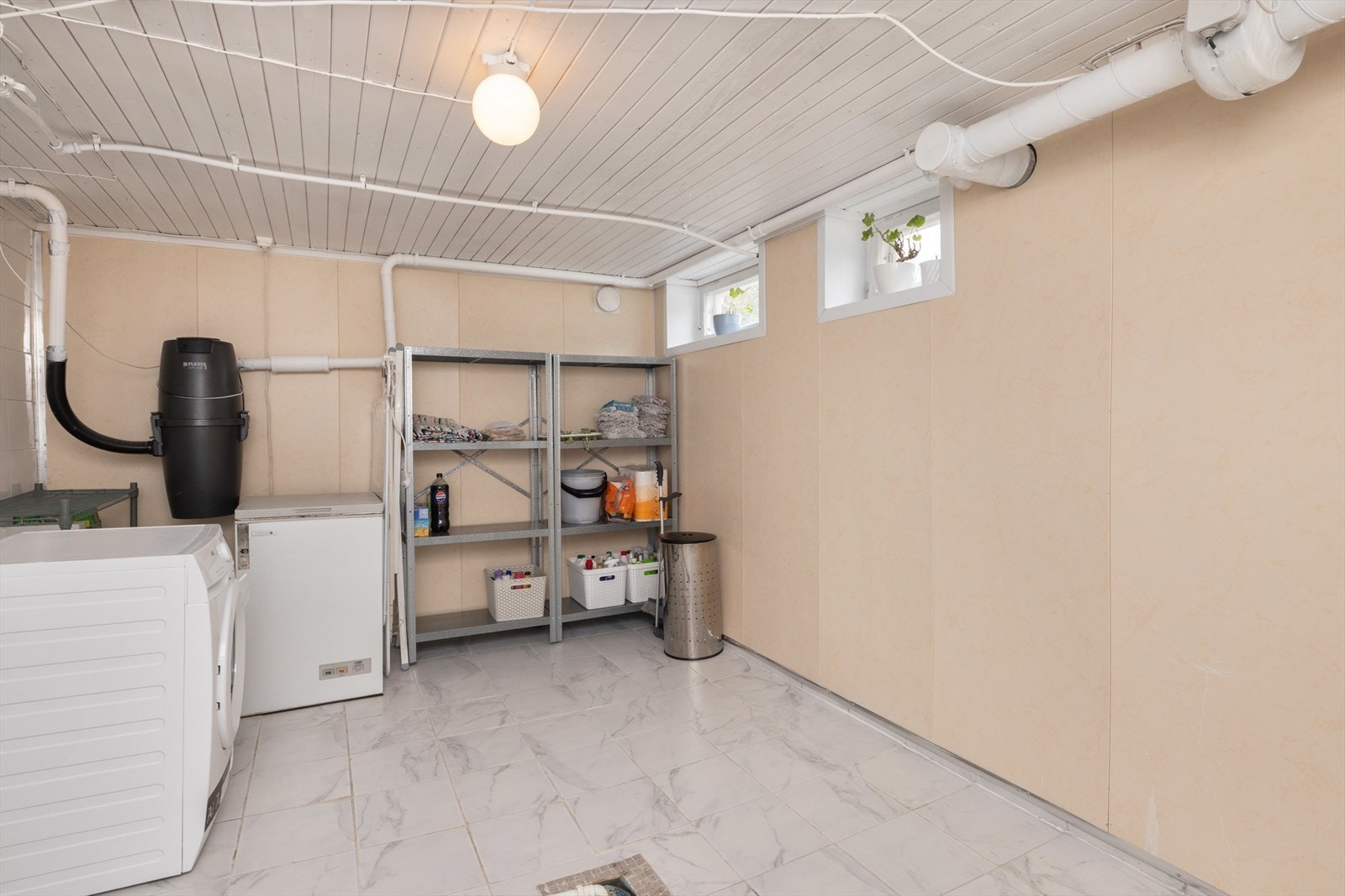 Boligen har også stort vaskerom med flislagt gulv, våtromsplater på veggene og opplegg for vaskemaskin. Boligen har sentralstøvsuger. Galleribilde