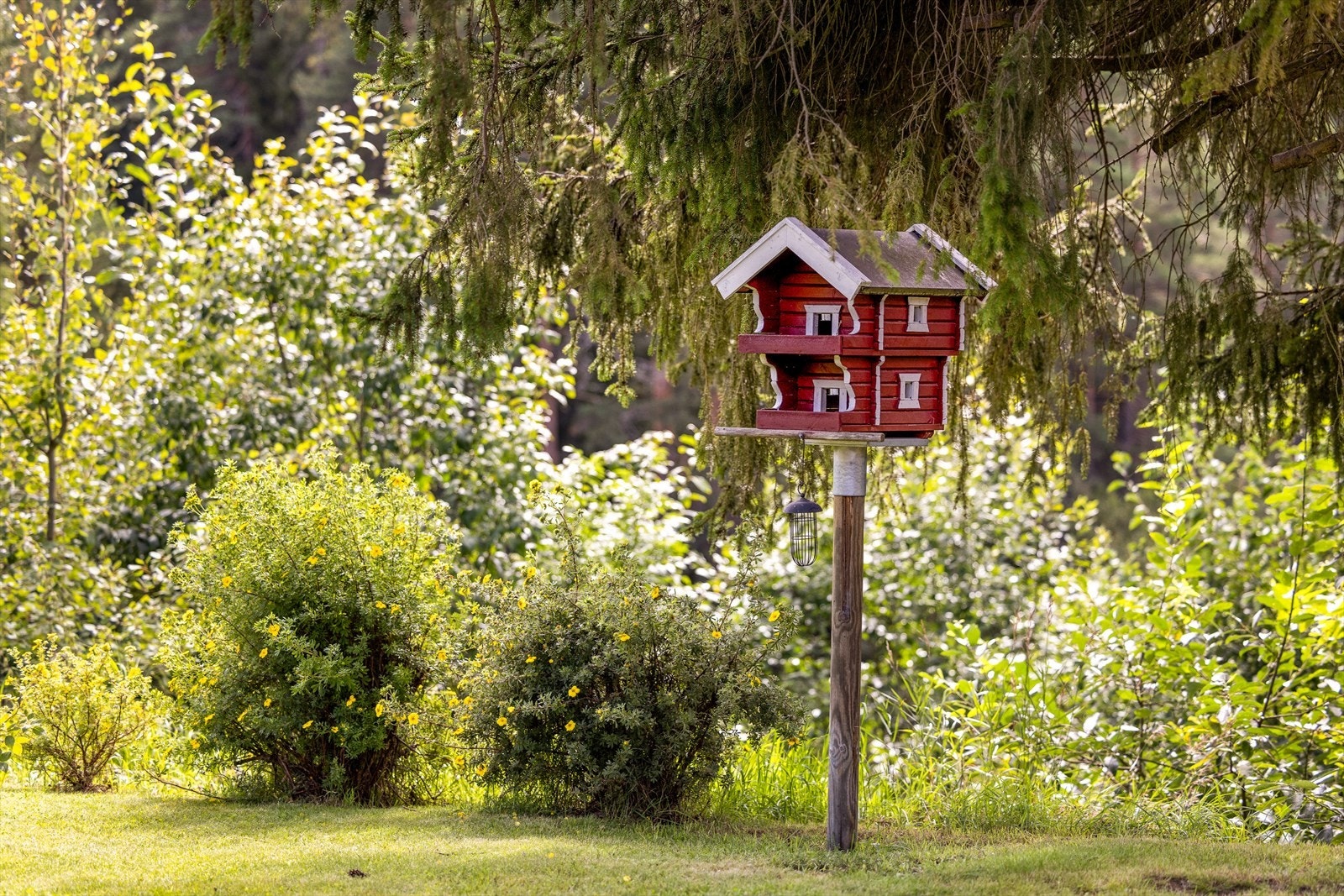 I hagen er det også et koselig rødt fuglehus formet som et stabbur. Galleribilde