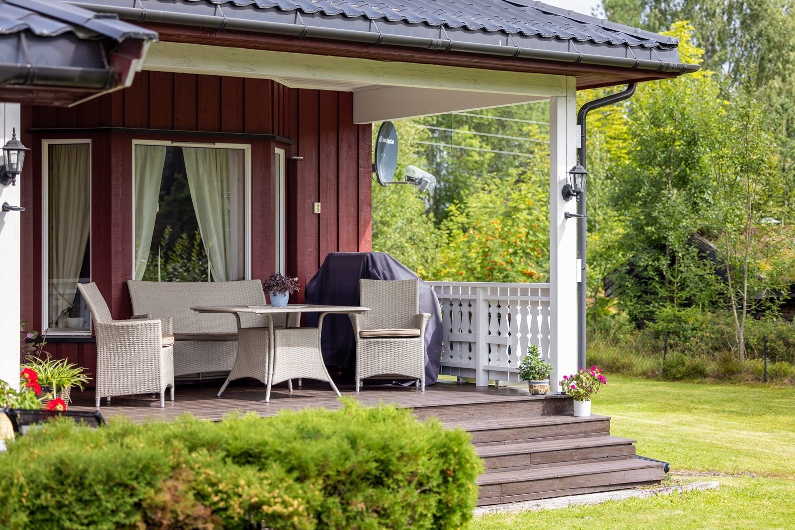 Terrassen er delvis overbygget, har impregnerte terrassebord på gulv og bred trapp ned til hagen. Det er montert både utebelysning og stikkontakt. Galleribilde