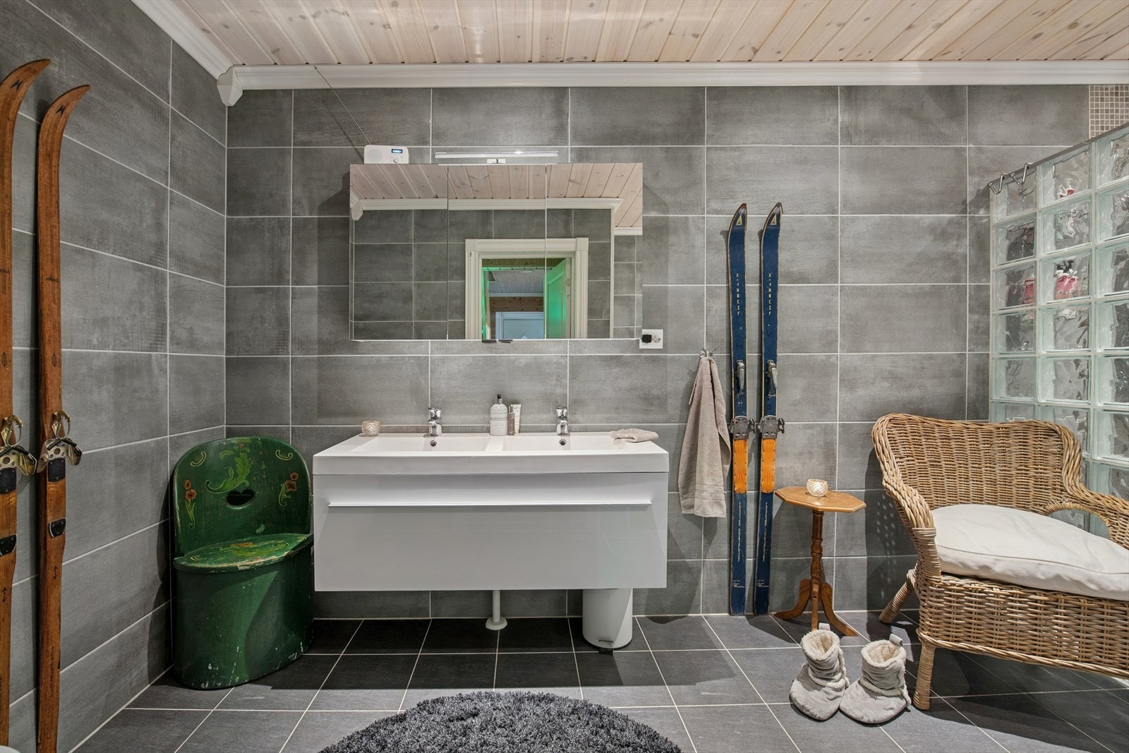 Underetasje - Lekkert og romslig bad med gjennomført stil. Her finner du både badekar med dusj, egen dusjnisje, dobbel servant med innredning og veggmontert toalett. Galleribilde