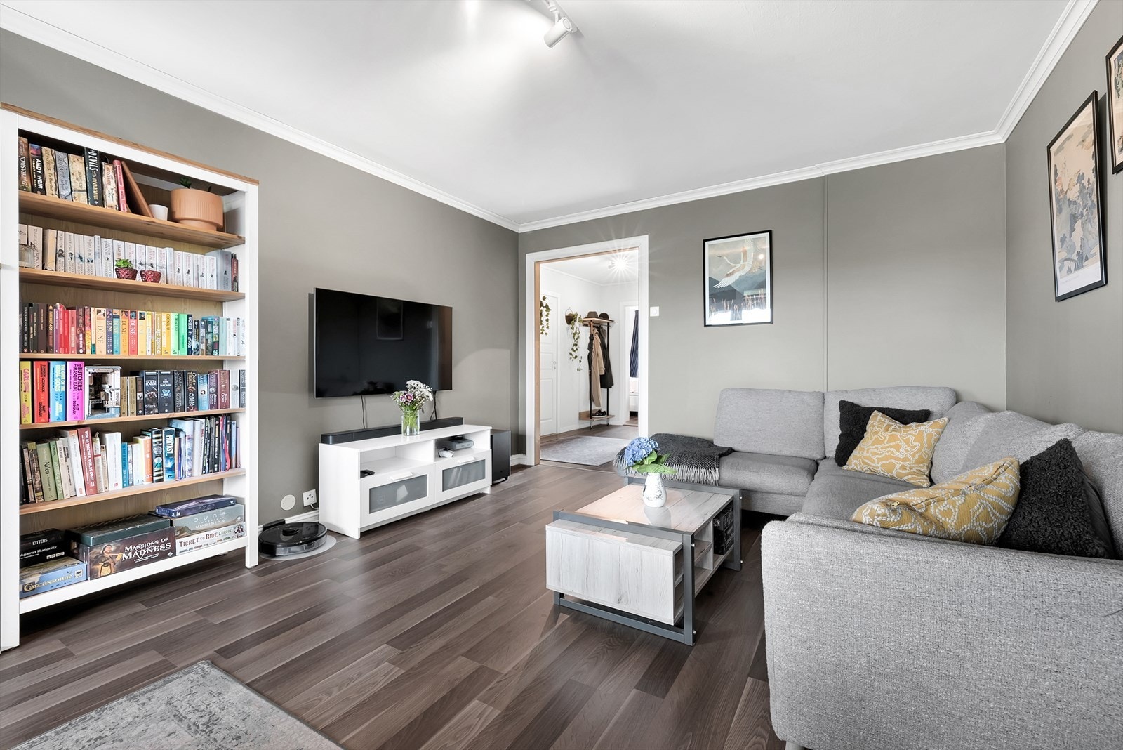 Romslig stue med laminatgulv og malte overflater, med en spottskinne i taket montert i 2021. Muligheter for montering av peis. Galleribilde