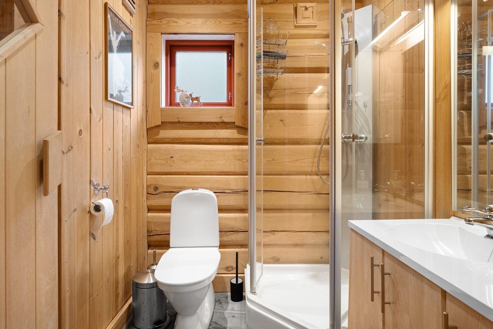 Innholdsrikt bad med toalett, dusjkabinett og innredning med servant Galleribilde