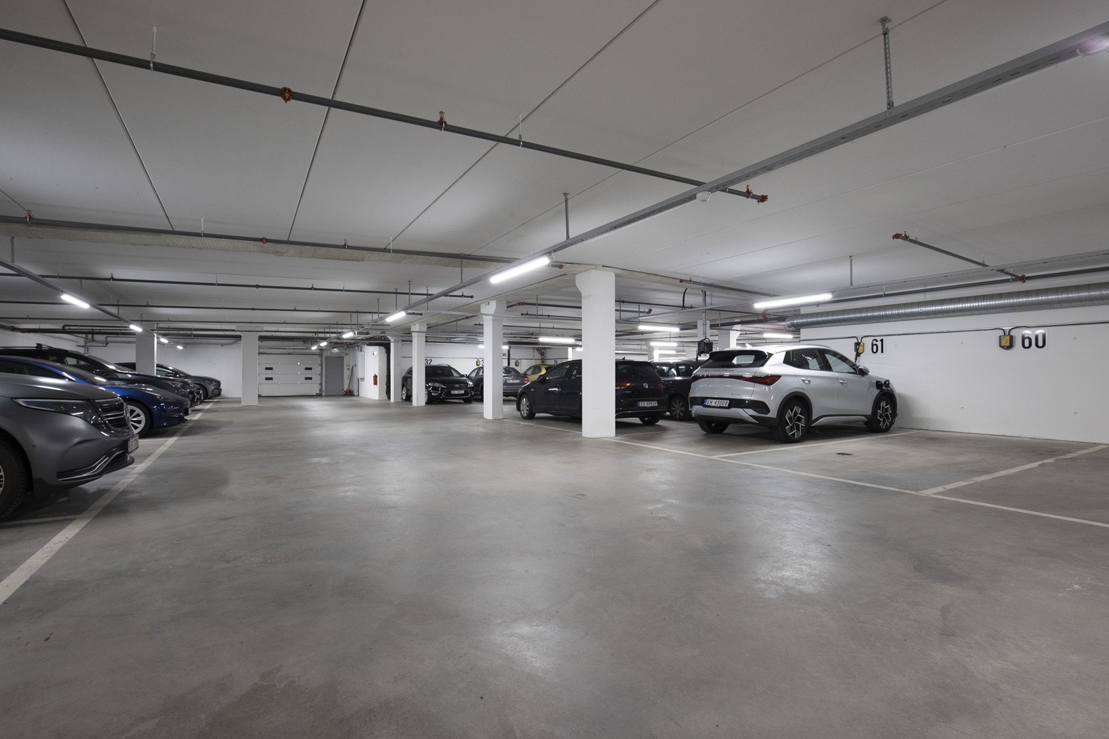 Parkering for en bil i felles garasje med ladepunkt. Eier må bestille ladeabonnement, så kommer laderen i posten. Strømuttaket er ferdig montert. Galleribilde