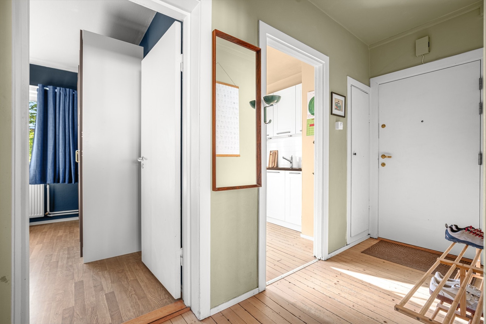 På gulvet er det sjarmerende originale tregulv, og entréen har oppheng for jakker og en praktisk plassbygd garderobe for ekstra oppbevaring Galleribilde