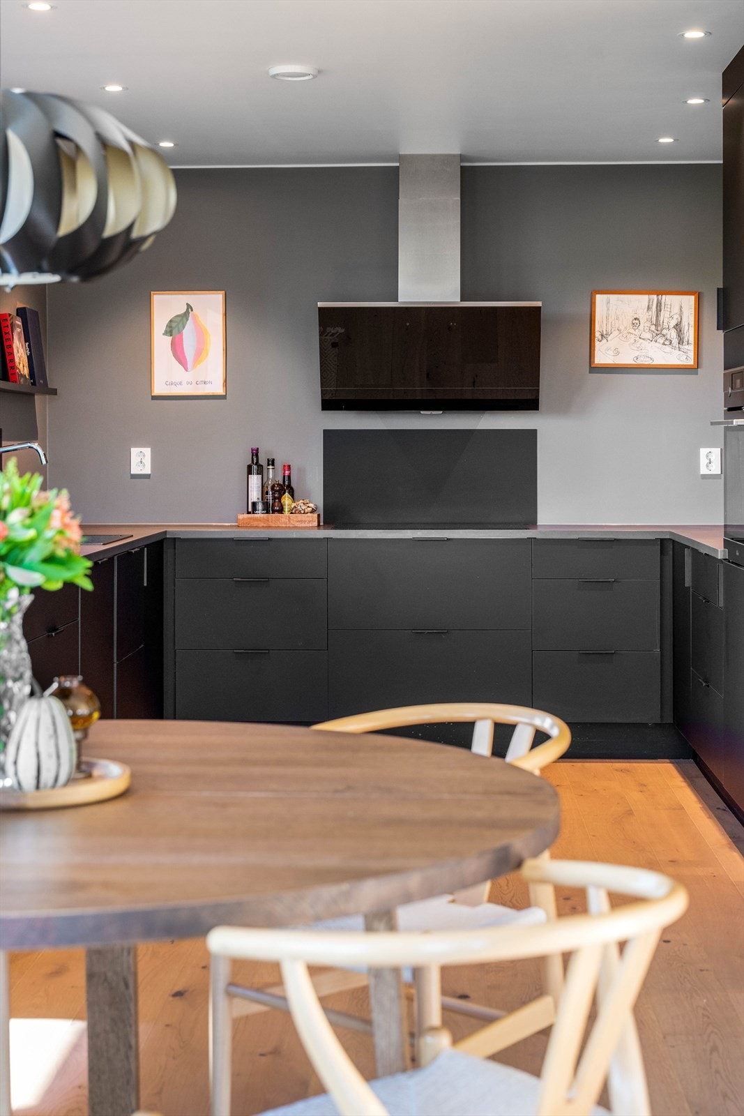 Stilrent og romslig kjøkken med mørk innredning og glatte fronter. Galleribilde