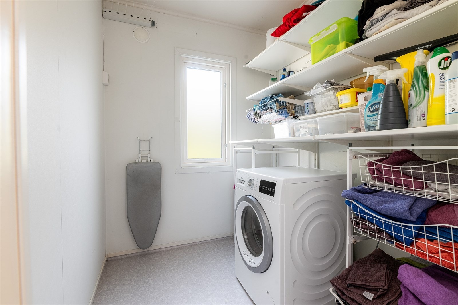 Vaskerom med opplegg til vaskemaskin, tørkesnor og hyllesystem som gir gode oppbevaringsmuligheter. Galleribilde