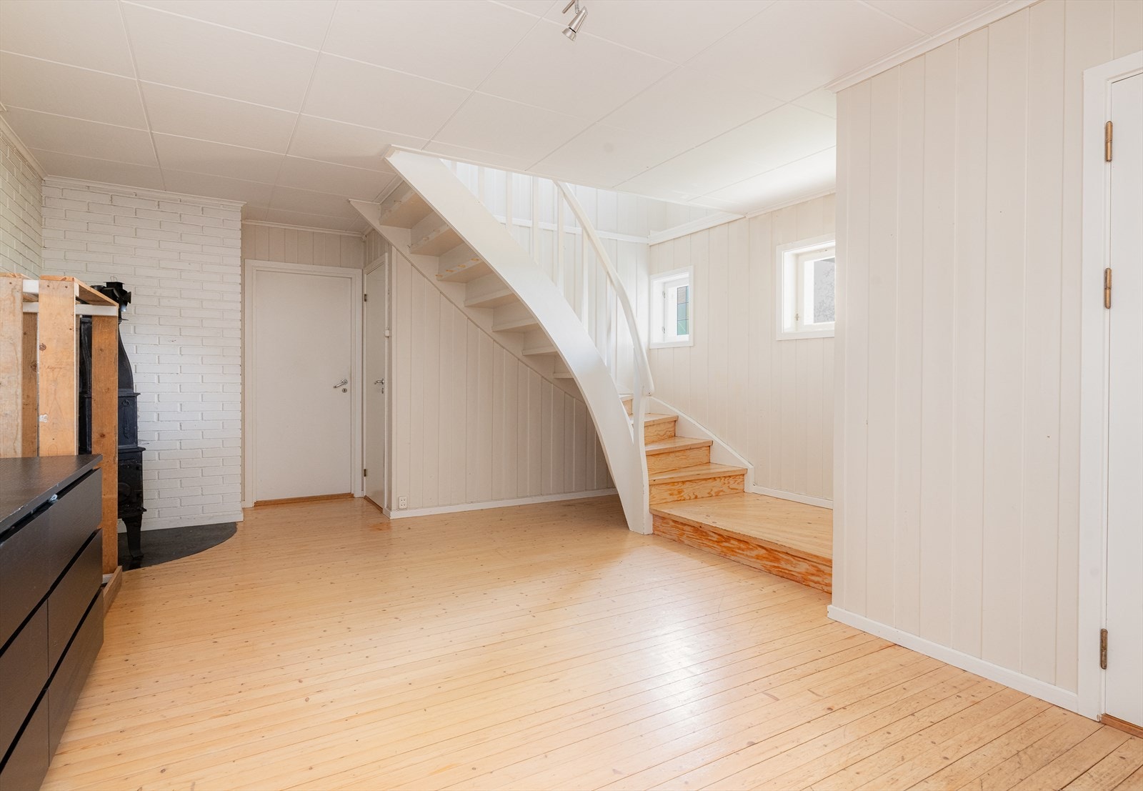 Gang i underetasjen er romslig og lys her står det peisovn som gir god varme på kalde dager. Galleribilde