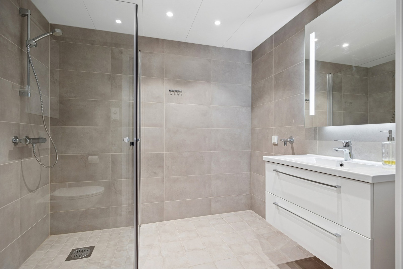 Lekkert og tidløst baderom fra byggeår, med flislagte gulv og vegger som gir et moderne uttrykk. Galleribilde