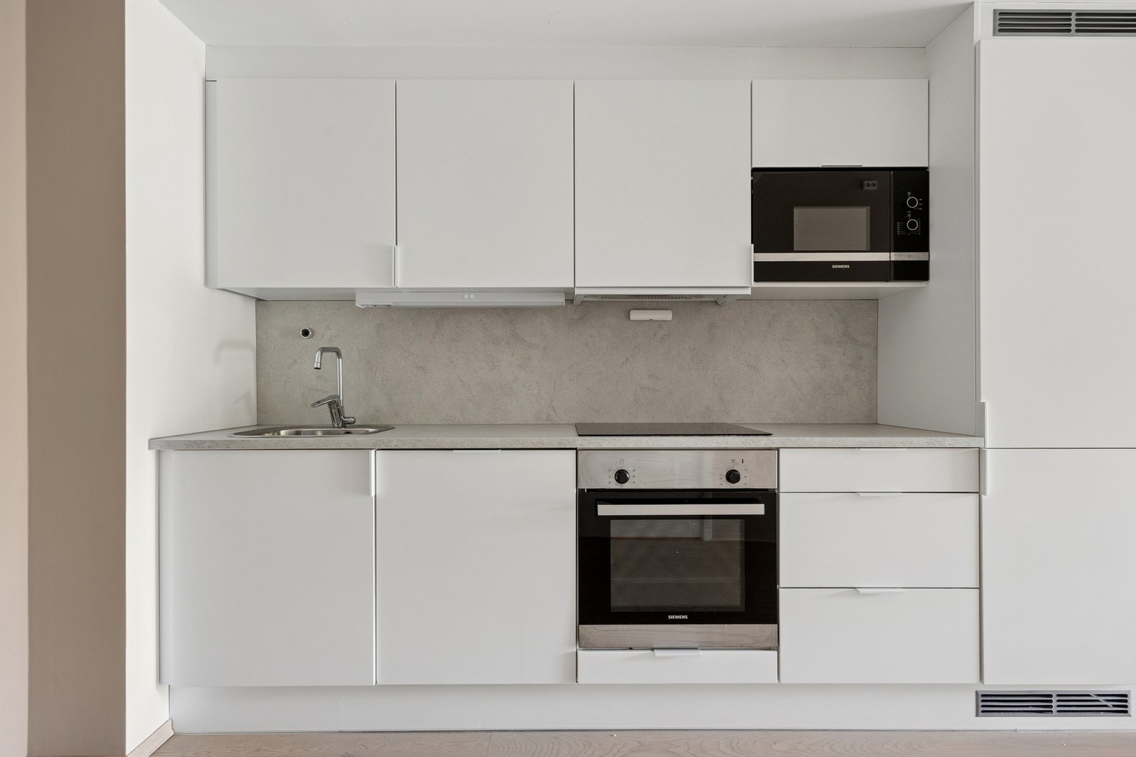 Stilrent kjøkken fra byggeår med glatte fronter, laminat benkeplate og integrert benkebelysning. Galleribilde