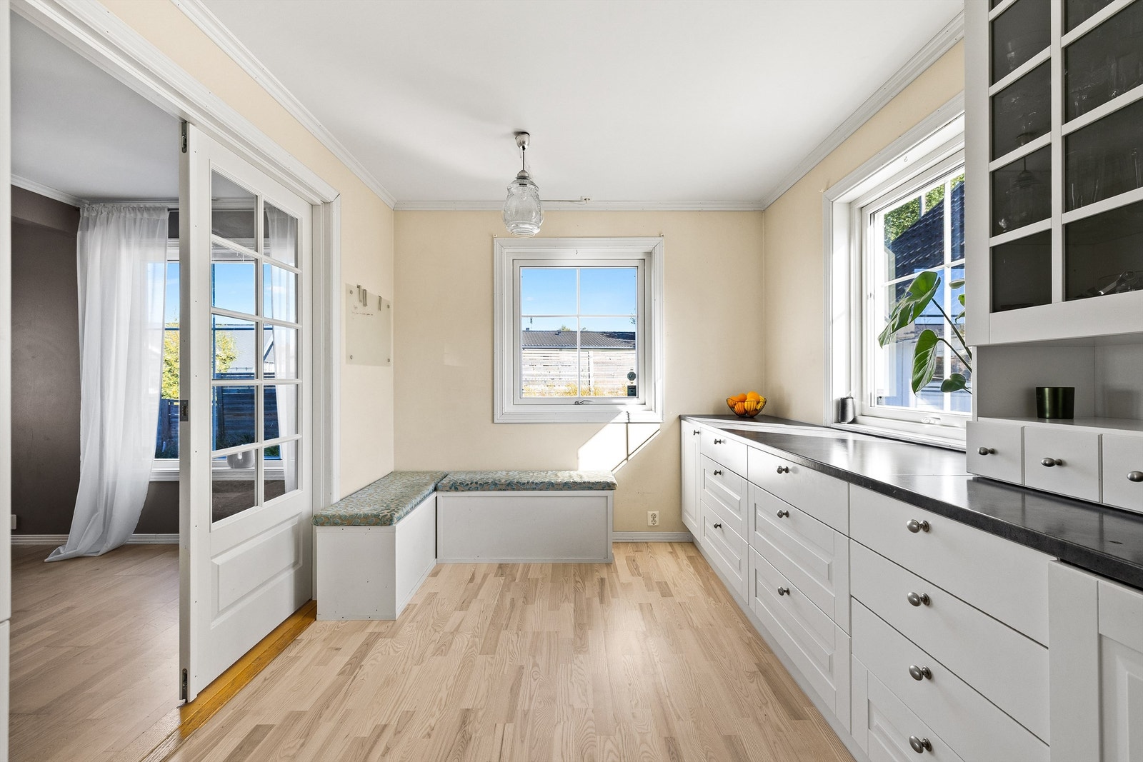 Store vindusflater gir godt med naturlig lys, og de doble glassdørene mot stue skaper en åpen og luftig forbindelse mellom rommene. Galleribilde