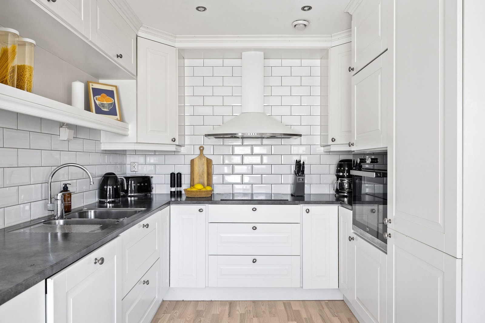 Benkeplatene er i laminat og overskapene har praktisk belysning under. Galleribilde