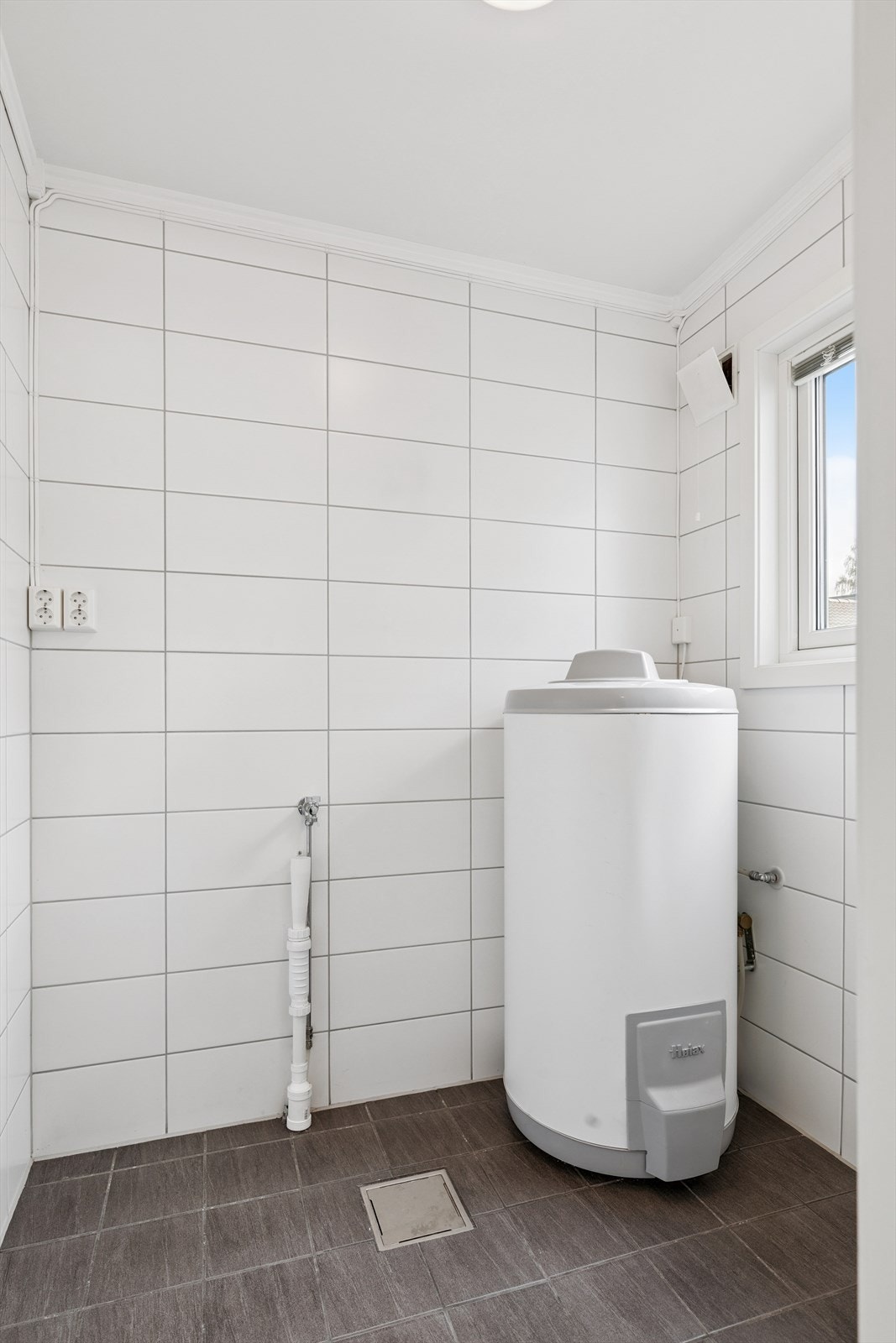 Og fislagt vaskerom i samme stil som wc og bad. Galleribilde