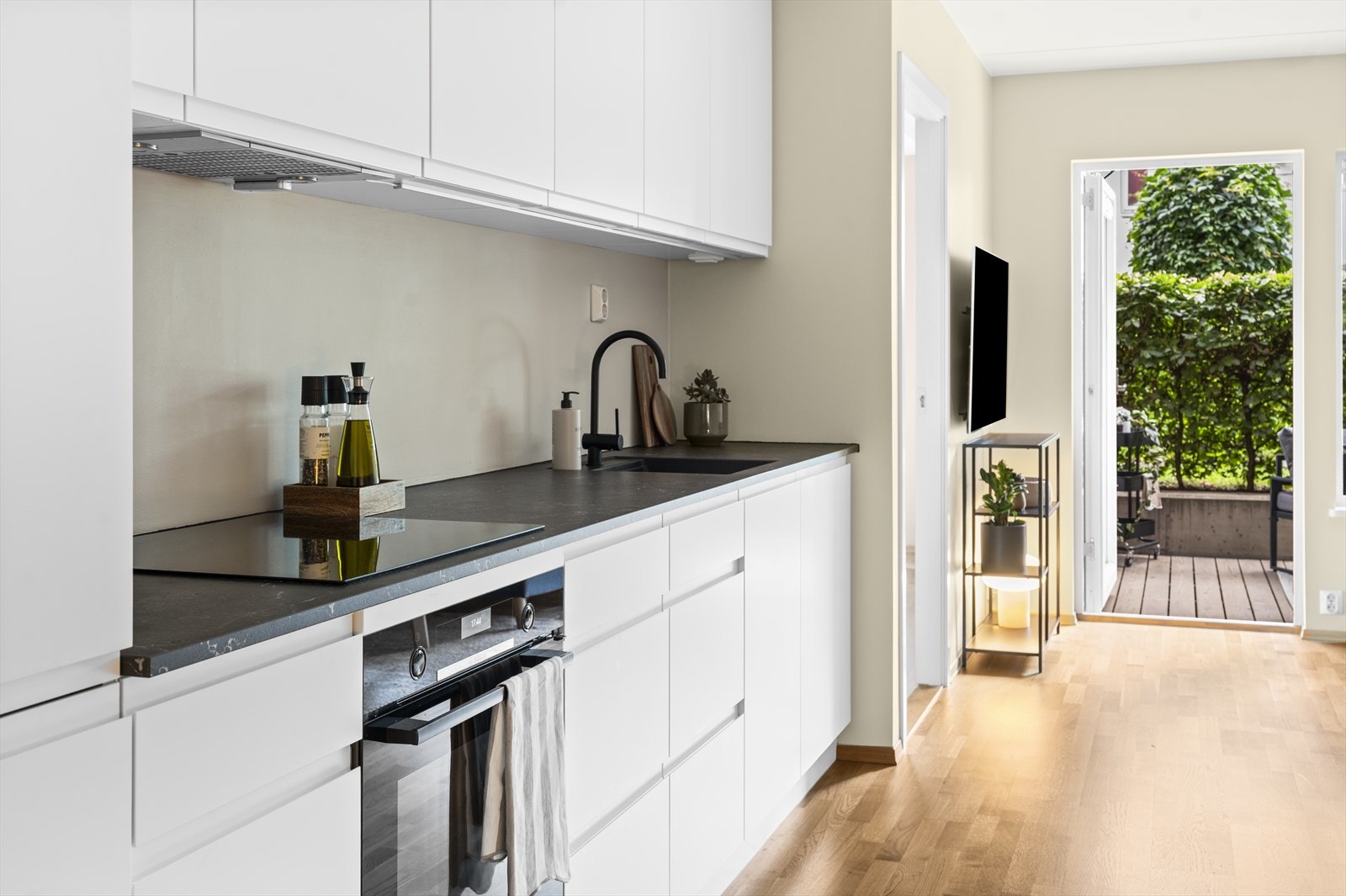 Lekkert kjøkken fra KVIK med ny kjøkkeninnredning fra 2021 med hvite, glatte fronter og laminat benkeplate Galleribilde