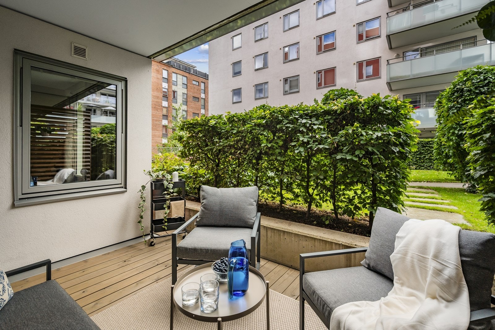 Terrassen har terrassebord i treverk og er trukket inn slik at man sitter lunt og godt gjennom sesongen Galleribilde