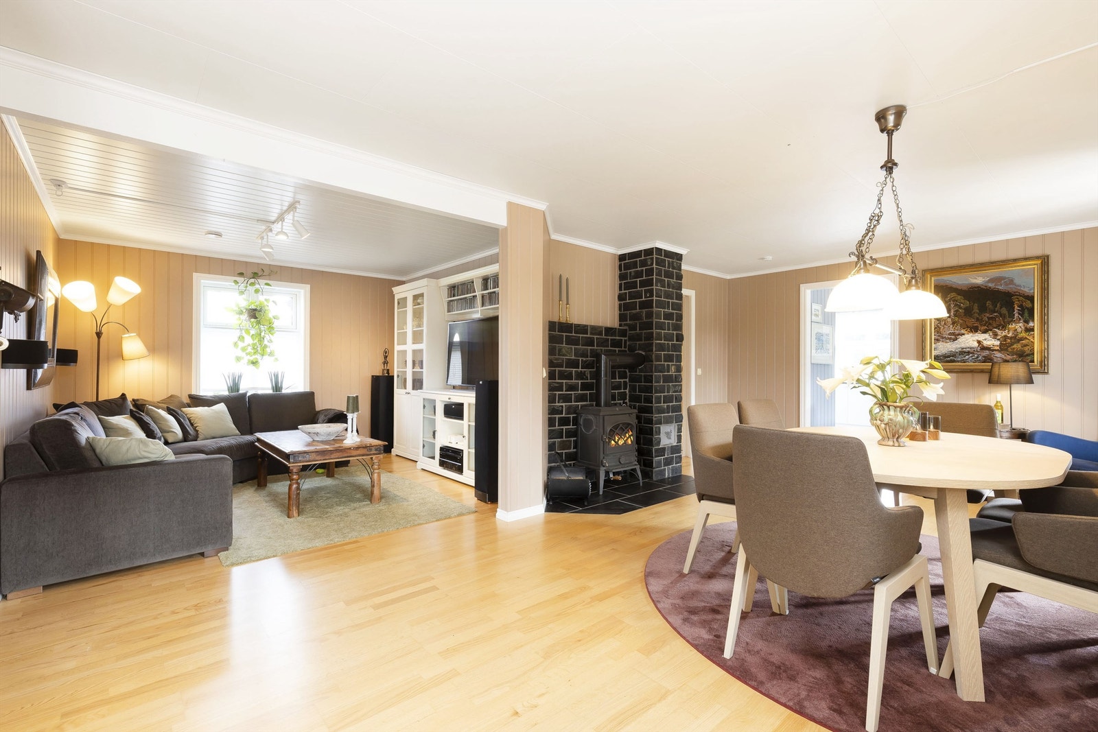 Koselig vinkelstue med parkett på gulv og peisovn Galleribilde