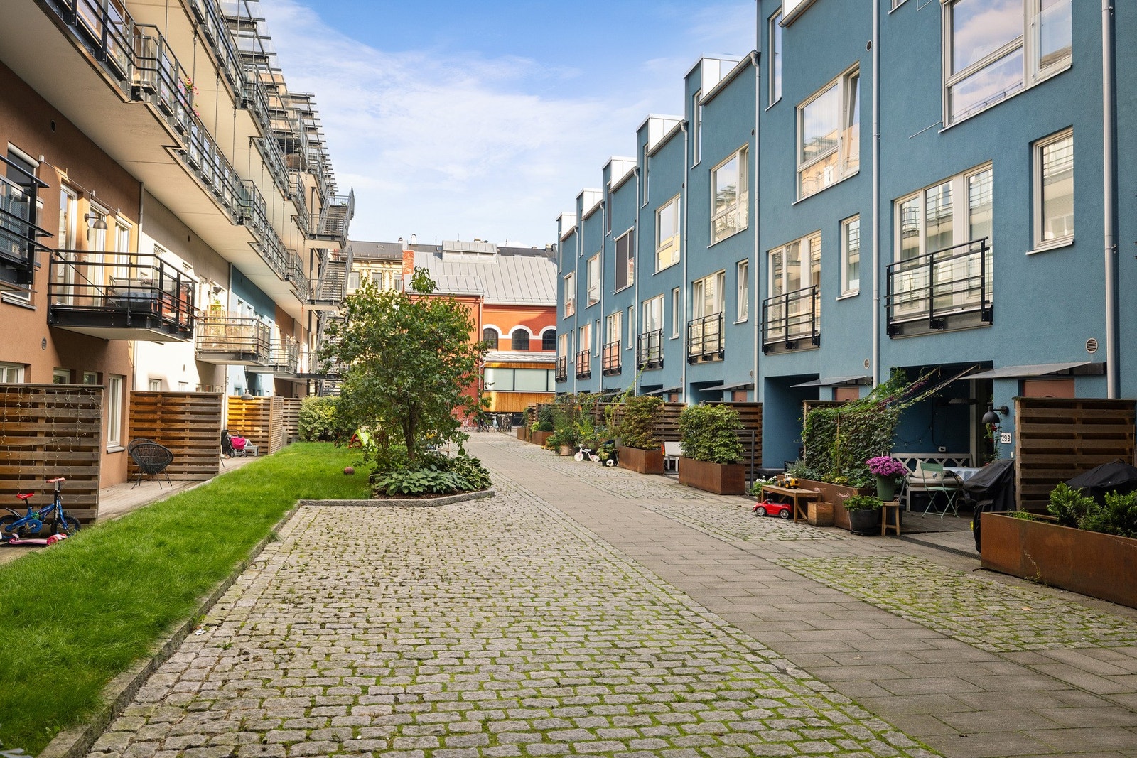 Restaurert fabrikkbygning i teglstein omkranset av nye townhouse og en lekker bakgård samt to takterrasser Galleribilde