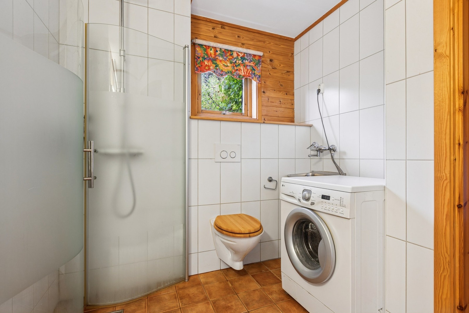 Rommet er utstyrt med dusjhjørne med innfellbare dusjdører, servant, veggmontert toalett, skyllekum og opplegg for vaskemaskin. Galleribilde