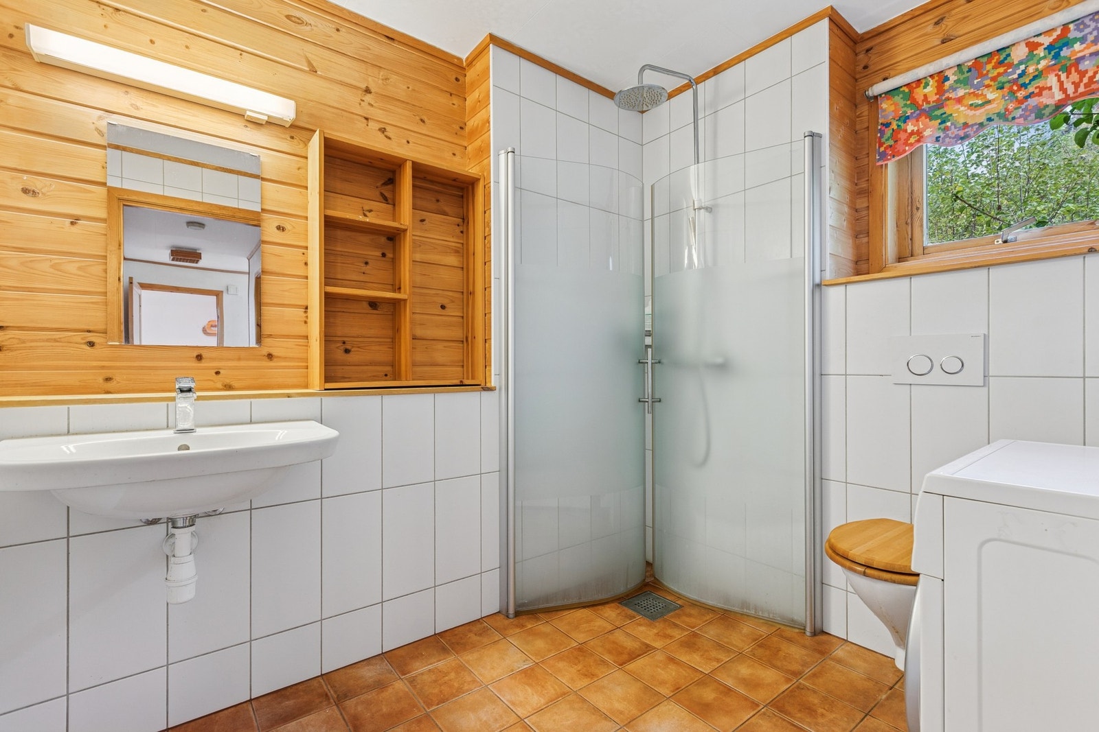 Badet har flislagt gulv med gulvvarme, samt kombinasjon av fliser og panel på veggene. Galleribilde