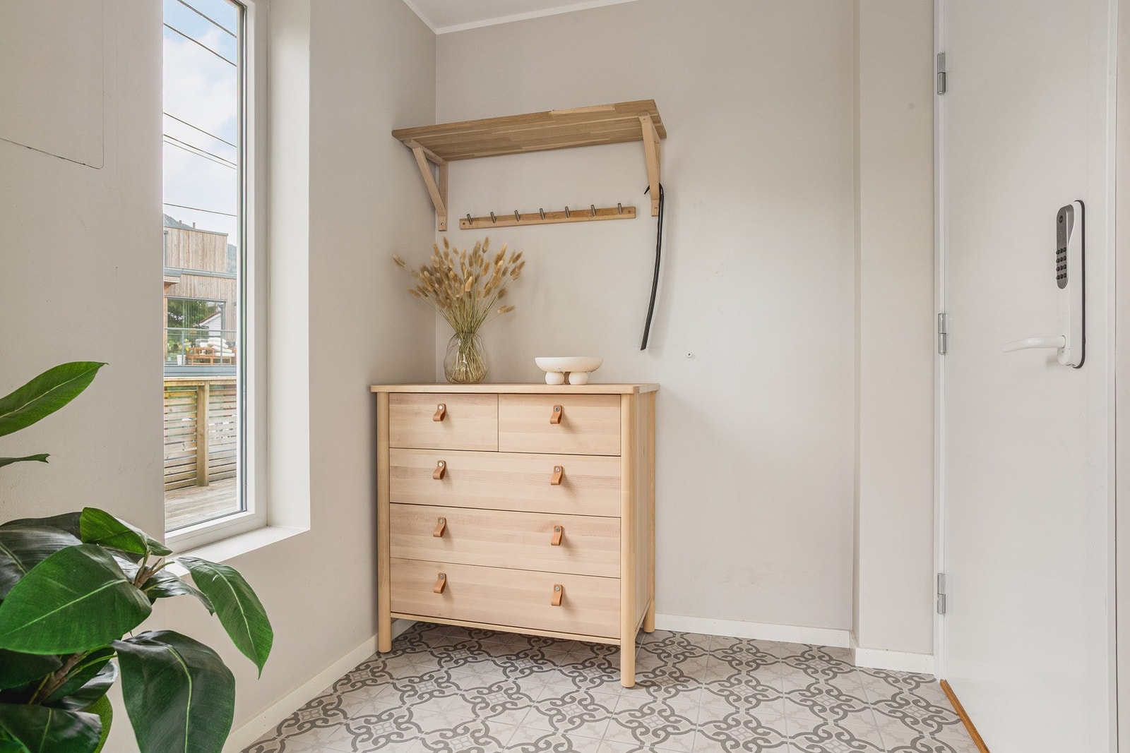 Lys og romslig entré med plass for klesoppheng og oppbevaring av sko i stor garderobe. Galleribilde