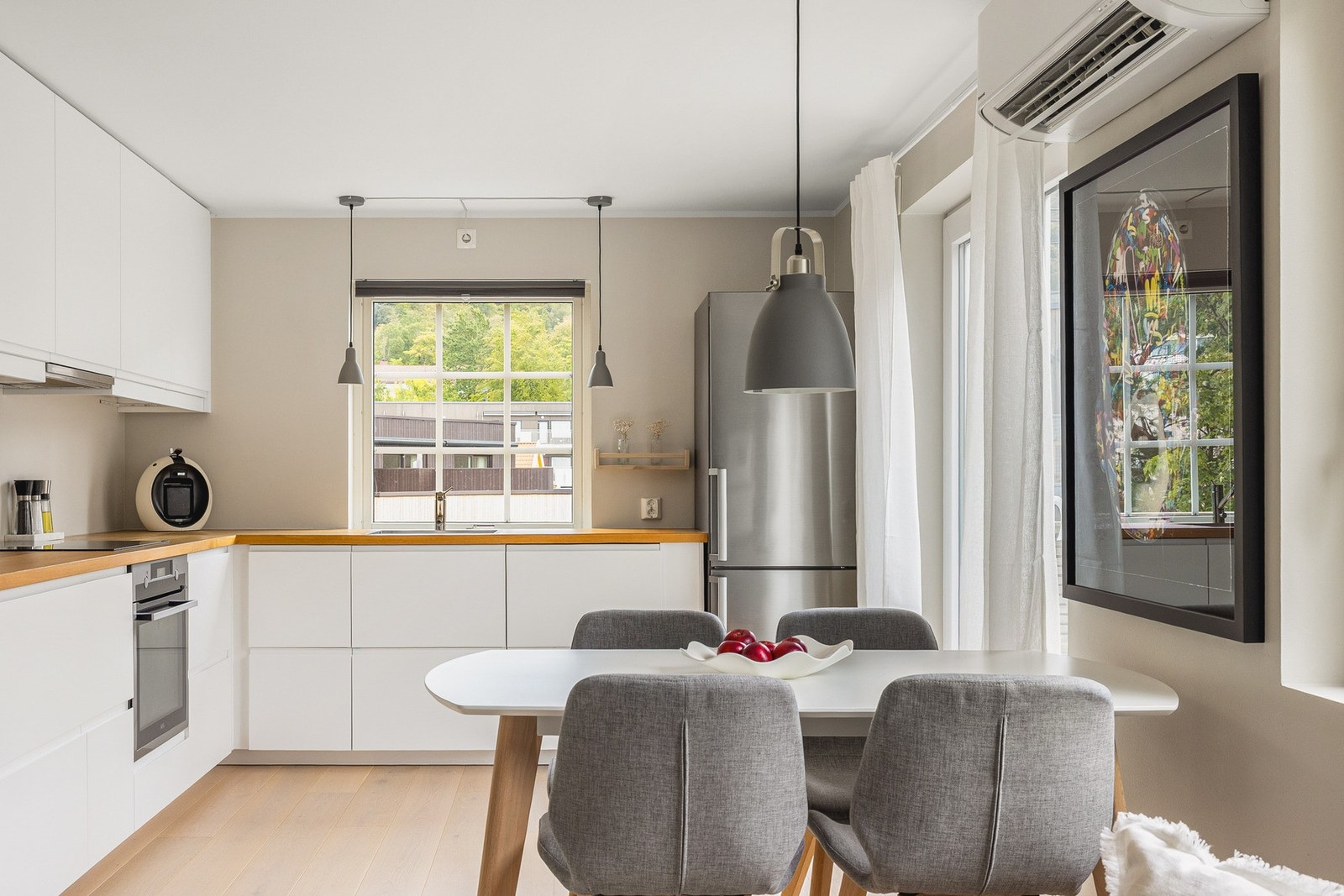 Med sin åpne løsning mot spisestuen og kjøkkenet skapes en naturlig flyt som gjør det enkelt å være sosial med familie og gjester. Galleribilde