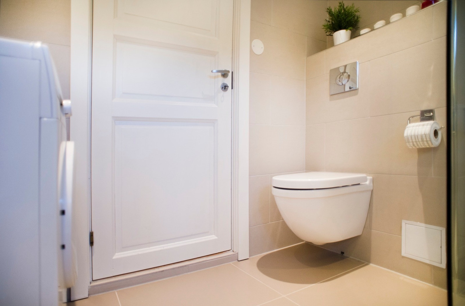 Innredning består av vegghengt toalett, baderomsinnredning, dusj med glassvegger og opplegg for vaskemaskin. Galleribilde