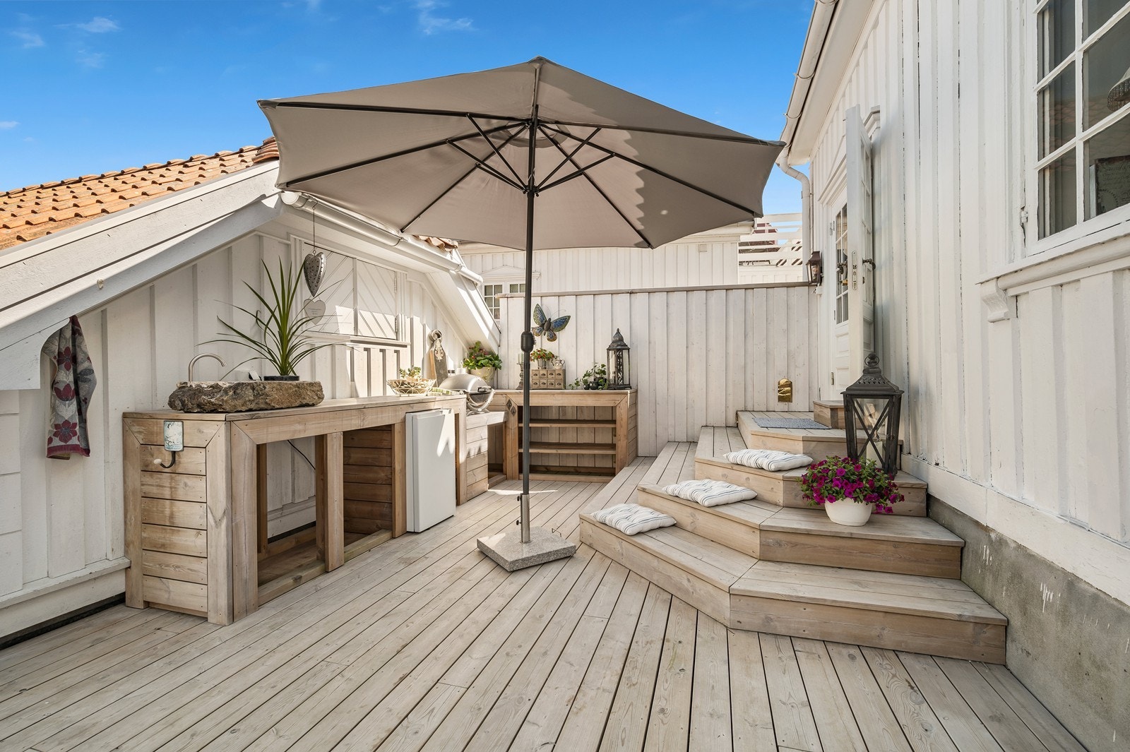 Utekjøkken med servant (avbildet servant medfølger ikke), plass til kjøleskap, tilkomst til stort lagringsloft over garasje, stor trapp med mulighet for sitteplasser mm. Galleribilde