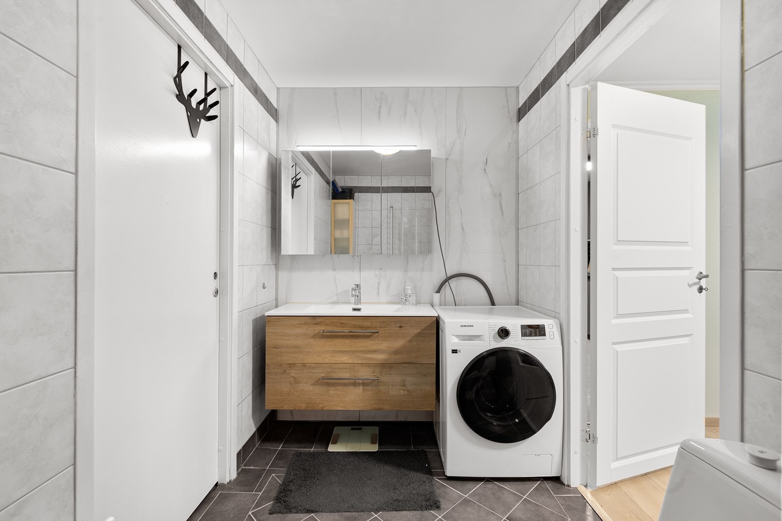 Pent flislagt bad med opplegg for vaskemaskin. Galleribilde