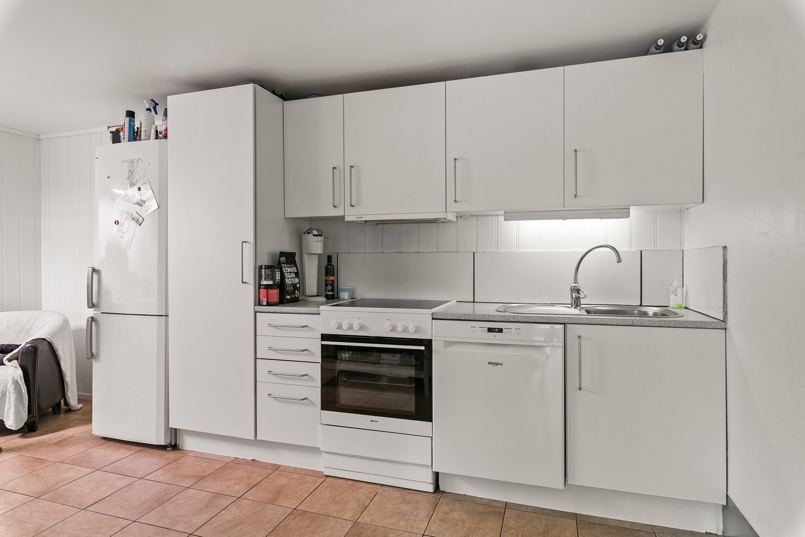 Kjøkkenet har en innredning med slette, hvite fronter og laminert benkeplate. Galleribilde