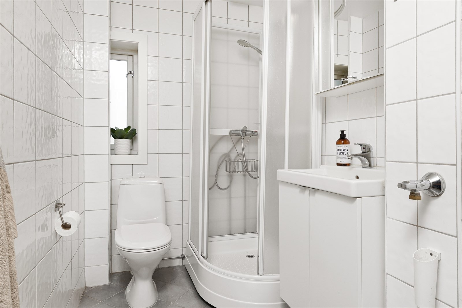 Helfliset baderom innredet med nedfelt servant, toalett, dusjkabinett og opplegg for vaskemaskin. Galleribilde