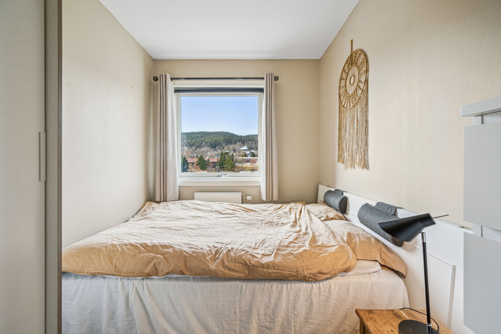 Lyst og luftig soverom med plass til dobbeltseng, nattbord og garderobeskap. Galleribilde