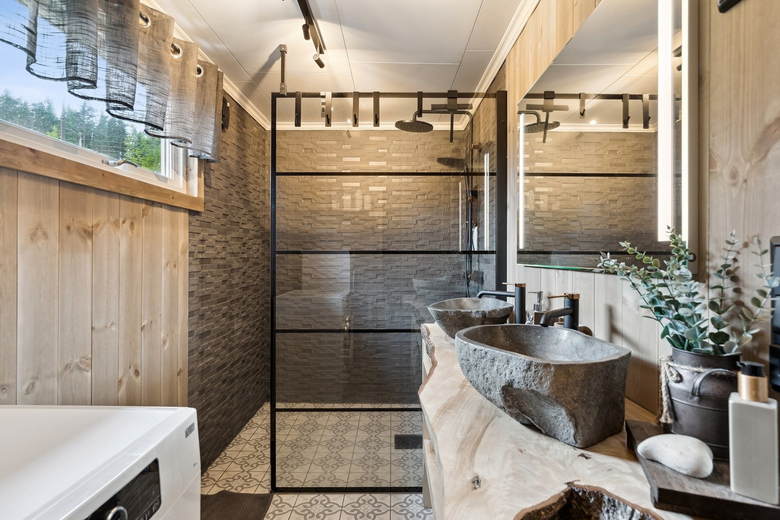 Flislagt baderom med gulvvarme. Plassbygget innredning med dobbelservant, dusj og har opplegg for vaskemaskin. Galleribilde