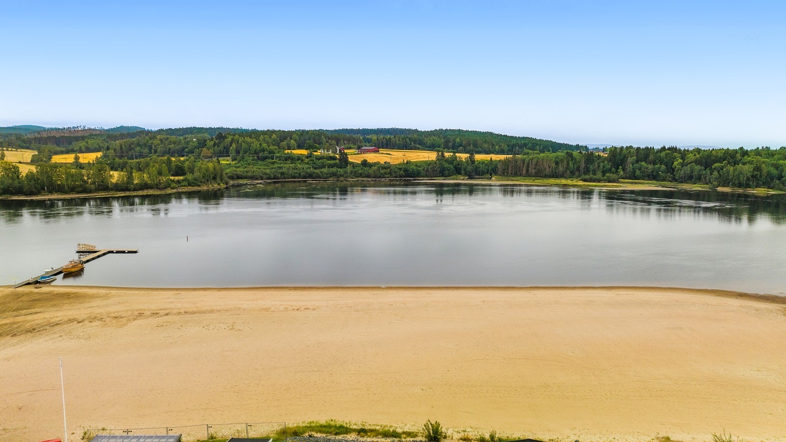 Oversiktsbilde av strand og nærområdet rundt hytta. Galleribilde