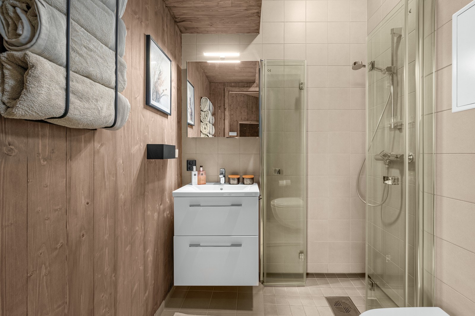 Stilrent bad med dusj, servant og godt med oppbevaringsplass. Galleribilde