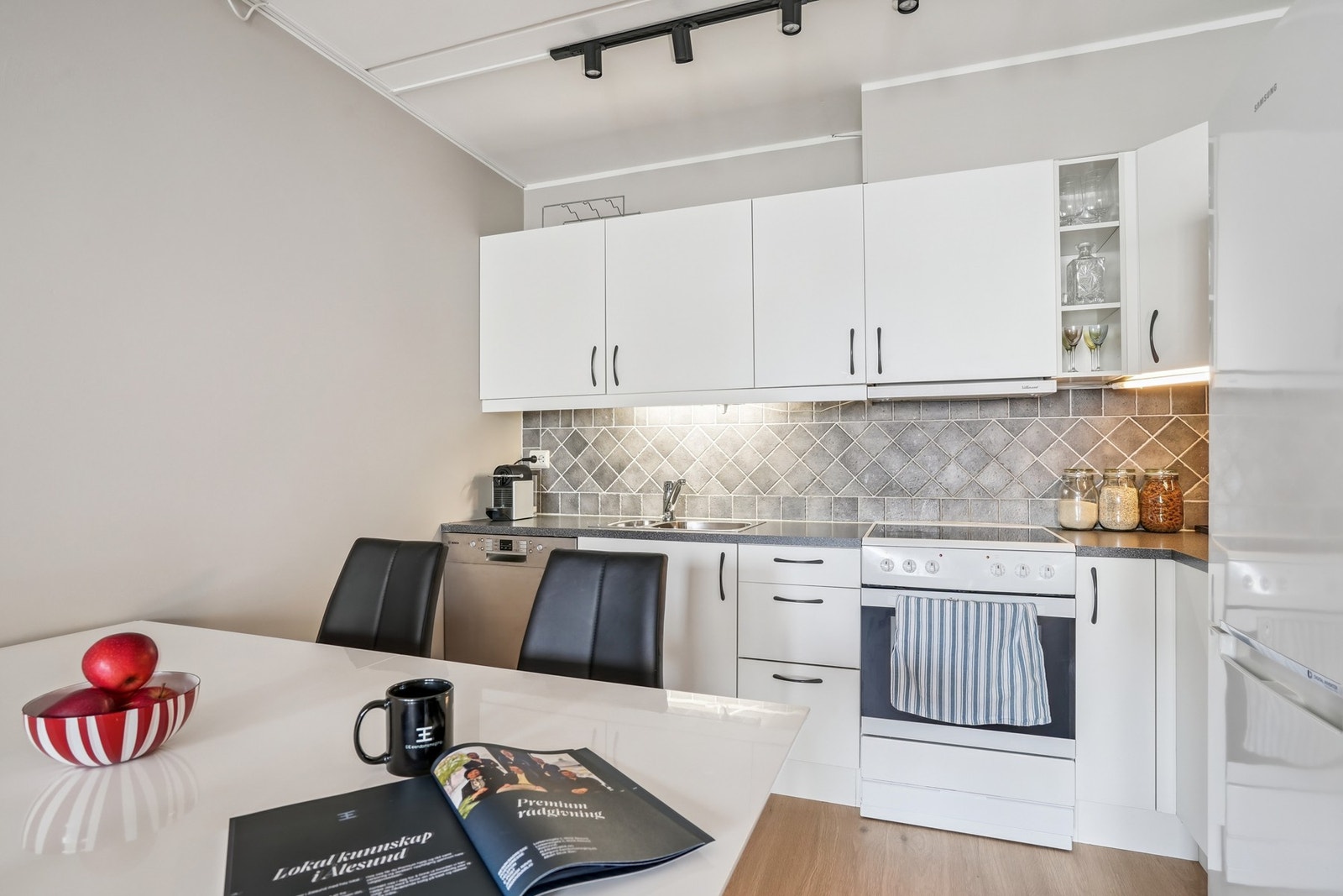 Flott kjøkken med kjøl-/fryseskap, oppvaskmaskin og komfyr. Galleribilde