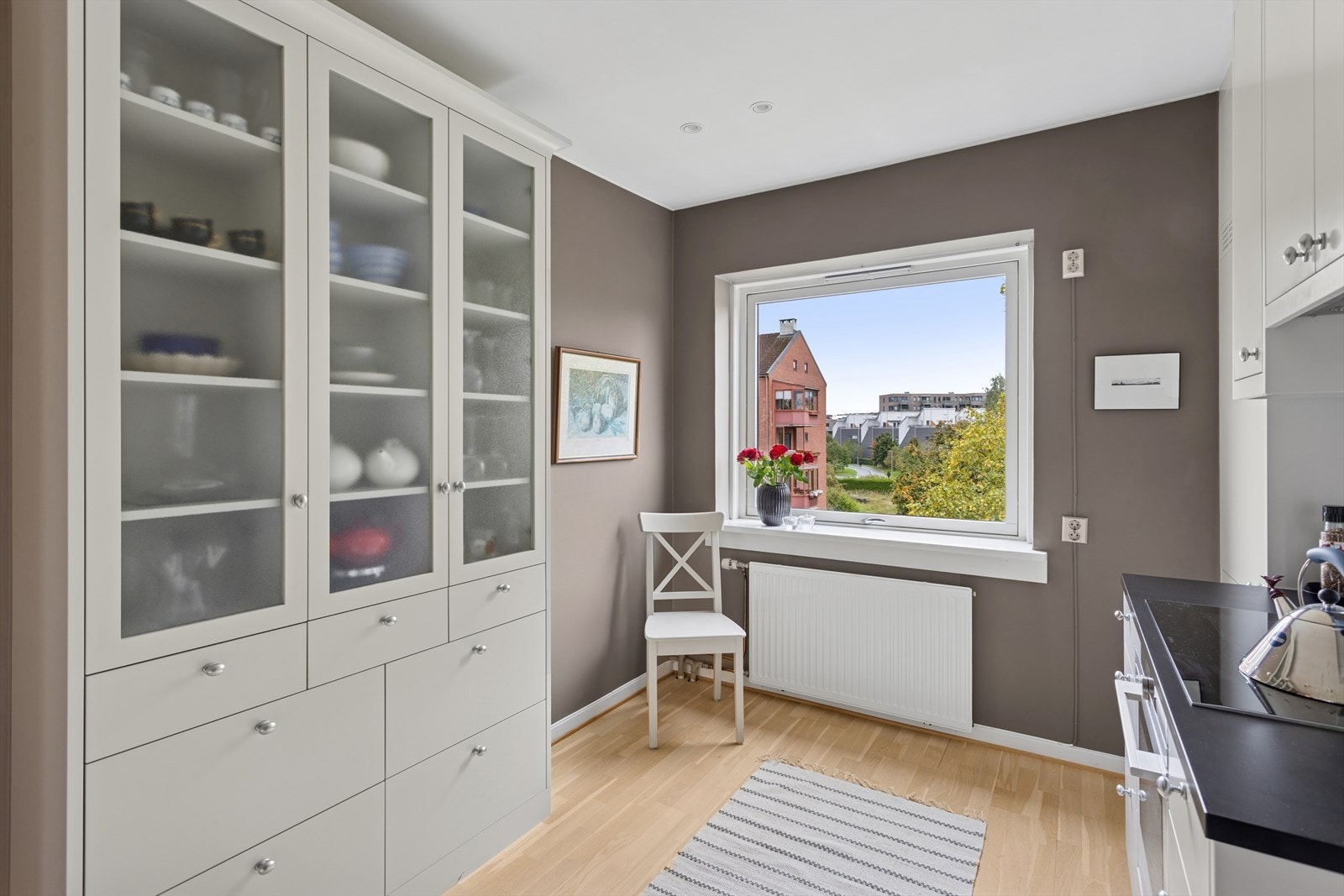 Et flott vitrineskap i samme stil som resten av kjøkkenet medfølger salget. Galleribilde